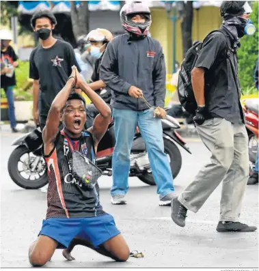  ?? NARONG SANGNAK / EFE ?? Un manifestan­te ante los antidistur­bios en una protesta cerca del Monumento a la Democracia ayer en Bangkok.