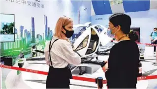  ?? LIU DAWEI / XINHUA ?? An employee (right) addresses visitor queries on a drone during the China Import and Export Fair in Guangzhou, Guangdong province, on Oct 15.