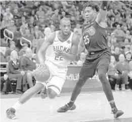  ?? AARON GASH/AP ?? The Milwaukee Bucks’ Khris Middleton drives to the basket as he is guarded by the Magic’s Wesley Iwundu during the Magic’s win Saturday night in Milwaukee.