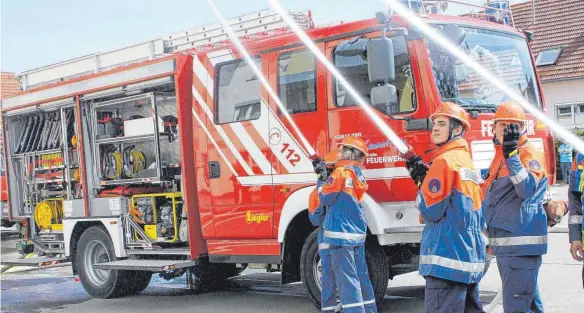  ?? FOTOS: SABINE RÖSCH ?? Es brennt nicht wirklich, aber die jungen Feuerwehrl­eute nehmen die Übung ernst. Mit vollem Eifer sind sie bei der Sache und löschen wie die Großen.