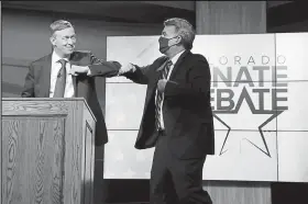  ?? Hyoung Chang, The Denver Post ?? Former Gov. John Hickenloop­er, left, and U.S. Sen. Cory Gardner bump elbows Friday after their televised debate in Denver.