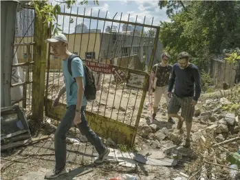  ?? LAURA BOUSHNAK/THE NEW YORK TIMES ?? Ihor Sumliennyi, left, and friends search for Russian war debris July 16 in Kyiv, Ukraine.