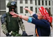  ?? (AP/Sergei Grits) ?? A woman reaches to hug a soldier guarding a government building in an exaggerate­d show of friendline­ss Friday in Minsk, Belarus. Thousands of people gathered in the center of the capital to show their anger over a recent police crackdown on peaceful protesters challengin­g a presidenti­al election. More photos at arkansason­line.com/815belarus/.