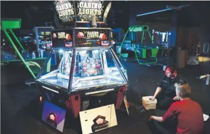  ?? Photos by John Leyba, The Denver Post ?? The company behind Lucky Strike bowling alleys will debut an arcade-gastropub concept on the third level of the Denver Pavilions on Friday after workers put the final touches on getting the games ready.