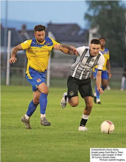  ?? ?? Ammanford’s Owyn Airey breaks away from Barry Town United’s Luke Cooper in their JD Cymru South clash.
Picture: Gareth Hughes.