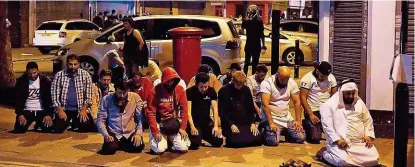  ??  ?? Dutzende Muslime beten spontan auf der Straße für die Opfer des blutigen Lkw- Anschlags.