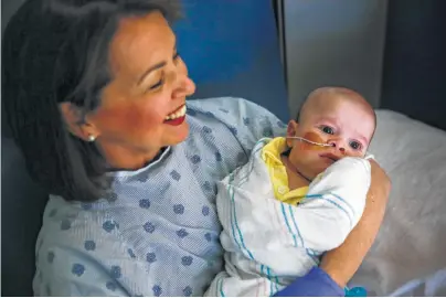  ?? Michael Ciaglo photos / Houston Chronicle ?? Nancy Baycroft, a volunteer baby rocker at Texas Children’s Hospital, holds 3-month-old Walter Omar Pineda-Real.