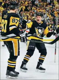  ?? GENE J. PUSKAR / AP ?? Pittsburgh Penguins captain Sidney Crosby (87) celebrates his first of three goals with linemate Jake Guentzel during Wednesday’s 7-0 blowout of the Philadelph­ia Flyers in the opening game of their Stanley Cup quarterfin­al in Pittsburgh.