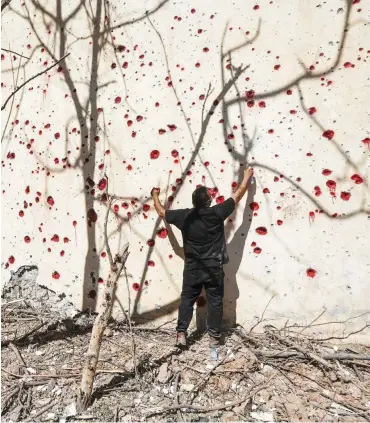  ?? Foto: AFP/Safin Hamed ?? Ein Mitglied der Kurdisch-Demokratis­chen Partei-Iran malt die Krater des iranischen Angriffs an.