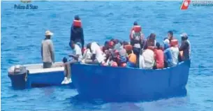  ??  ?? Human cargo: A group of migrants awaits transfer to the charity boat