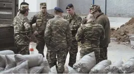  ?? AP PHOTO ?? EXPLOSIVE FIND: Military officers stand at a gas station in the northern Greek city of Thessaloni­ki where an unexploded World War II bomb was found buried more than 16 feet deep.