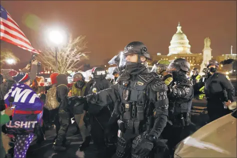  ?? Spencer Platt / Getty Images ?? Above, Members of the National Guard keep a group of demonstrat­ors away from the Capitol during the Jan. 6 riot.