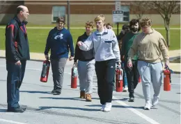  ?? ?? Teacher Eric Gopen talks with his Parkland High School students April 11 as they carry fire extinguish­ers outside for a lesson on firefighti­ng.