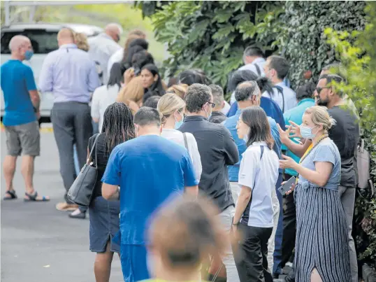  ?? Photo / Alex Burton ?? Health workers queue at Waipuna Hotel in Auckland to receive their Covid-19 vaccinatio­n. — a month earlier than they had been expecting.