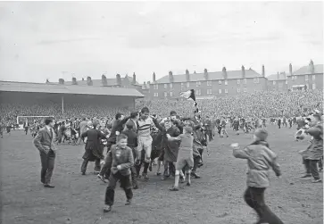  ??  ?? The scene after Dundee United’s Second Division game on April 30 1960 with the players being surrounded by fans. United beat Berwick Rangers 1-0 to finish second in the league and win promotion to the First Division.