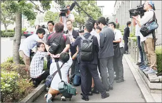  ??  ?? Media interviews a stockholde­r before Japanese air bag maker Takata Corp, shareholde­rs’ meeting in Tokyo on June 27. Takato Corp has filed for bankruptcy, brought down by a scandal involving defective air bags blamed for
at least 16 deaths. (AP)