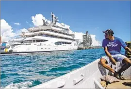  ?? Leon Lord Fiji Sun ?? EMOSI DAWAI looks at the Amadea in April at Lautoka harbor in Fiji, where the high court Tuesday lifted a stay that had prevented the U.S. from seizing it.