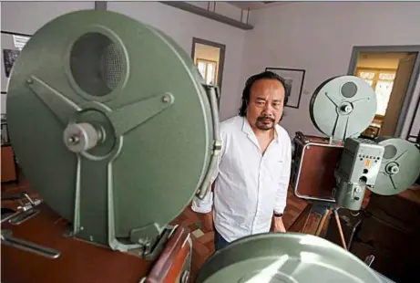  ??  ?? Preservati­on drive: Cambodian film director Rithy Panh looking at movie equipment at the Bophana centre in Phnom Penh. He has dedicated his life to seeking out and restoring lost films he believes tell the story of his country. — EPA Photo/Mak Remissa