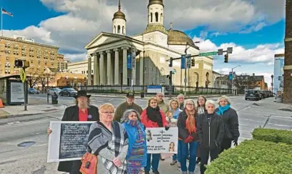  ?? KENNETH K. LAM/BALTIMORE SUN ?? Standing across from the Baltimore Basilica are a dozen people representi­ng the hundreds who shared their stories with authoritie­s as part of a four-year investigat­ion by the Maryland Attorney General’s Office into sexual abuse within the Catholic Church. On Friday, a judge ruled that a redacted version of the investigat­ion report could be publicly released.