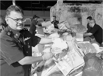  ??  ?? Sundraling­am showing the drugs for disposal in Kuala Lumpur. — Bernama photo