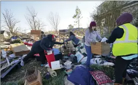  ?? GERALD HERBERT — THE ASSOCIATED PRESS ?? Volunteers, mostly from the Mayfield Consumer Products factory, help salvage possession­s from the destroyed home of Martha Thomas in the aftermath of tornadoes that tore through the region several days earlier, in Mayfield, Ky.