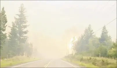  ?? TWITTER/SALLY AITKEN VIA CP ?? A wildfire burns by the side of the highway in British Columbia’s West Chilcotin region in this handout photo taken from video.