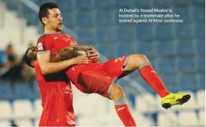  ??  ?? Al Duhail’s Yousef Msakni is hoisted by a teammate after he scored against Al Khor yesterday.