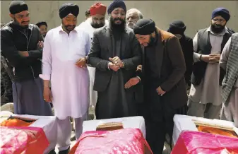  ?? Tamana Sarwary / Associated Press 2020 ?? Afghan Sikh men mourn loved ones during a funeral procession in 2020 for those killed when a lone Islamic State gunman rampaged through a Sikh house of worship in Kabul.