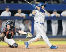  ?? MATT STAMEY/AP ?? Florida outfielder Austin Langworthy hits a walk-off home run against Auburn in the bottom of the 11th inning of Monday’s game.