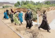  ?? RICK BOWMER/The Associated Press ?? Authoritie­s face a delicate task trying to help residents in the polygamous towns of Hildale and Colorado City where at
least 12 people were killed by flash floods last week.