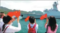  ?? CHEN JUN / CHINA NEWS AGENCY ?? Chinese Vietnamese wave flags at Cam Ranh Internatio­nal Port to welcome the Chinese naval fleet, which started a five-day visit on Saturday.