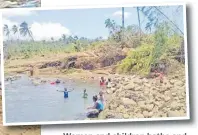  ?? Pictures: SERAFINA SILAITOGA ?? Women and children bathe and wash their clothes in a river that flows near the village.