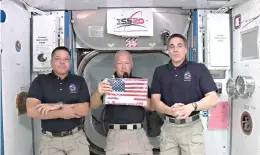  ?? NASA via AP ?? In this image taken from NASA video on Monday, NASA astronauts Robert L. Behnken, left, and Chris Cassidy right, listen as commander Douglas Hurley speaks about retrieving the American flag left behind at the Internatio­nal Space Station nearly a decade ago.