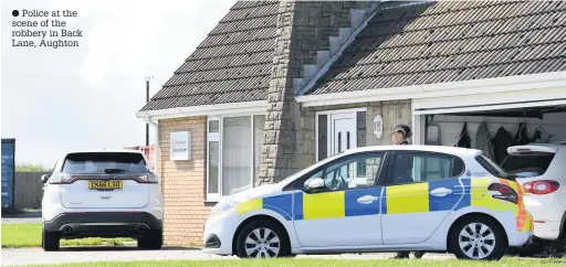  ??  ?? ● Police at the scene of the robbery in Back Lane, Aughton