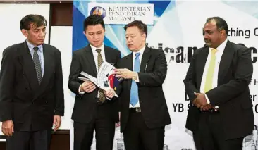  ??  ?? Raising English proficienc­y: Chong (second from left) and Eric Chong (third from left) going through the programme report. With them are Erican Education Group executive vice chairman Aslam Khan Samahs Khan (left) and chief operating officer and...