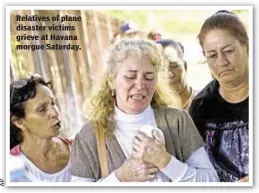  ??  ?? Relatives of plane disaster victims grieve at Havana morgue Saturday.