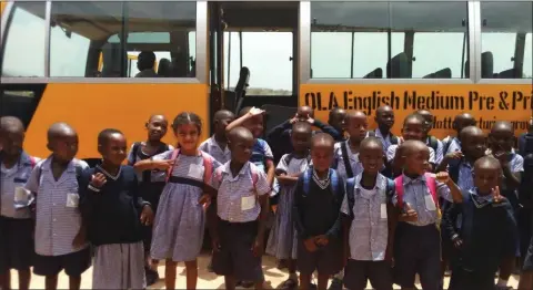  ??  ?? Pupils of Bugisi English Medium OLA Primary School beside the new bus.