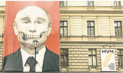  ?? FOTO: ALEXANDER FARNSWORTH/DPA ?? In der Hauptstadt Riga brachte das Museum für Medizinges­chichte an seiner Fassade ein großes Plakat mit einem als Totenkopf stilisiert­en Porträt Wladimir Putins an.