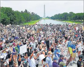  ??  ?? (Left) Demonstrat­ors gather at the Lincoln Memorial during a protest against racism, and (right) a man holds up a child during the protest, in Washington, DC