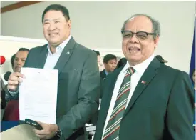  ?? (PNA FOTO) ?? OFFICIAL ACT. Rep. Reynaldo V. Umali (left), chairperso­n of the House committee on justice, displays the show-cause order against Sen. Leila de Lima, which was served at the office of Senate Secretary Lutgardo Barbo (right) at the Senate Building in...