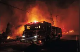  ?? JASON PIERCE/SACRAMENTO BEE ?? A fire engine drives past the Soda Rock Winery in Healdsburg early Sunday morning as the Kincade Fire expands.