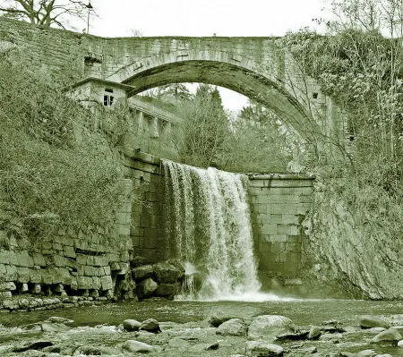  ??  ?? Il rione La Busa è un piccolo quartiere con le case incastonat­e in una piega rocciosa ai piedi del Calisio. A fianco una foto d’epoca