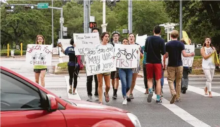  ?? Godofredo A. Vasquez photos / Houston Chronicle ?? BikeHousto­n, Rice University students, faculty, staff and members of the community march for safety at Sunset Boulevard and Main Street. A woman was fatally struck by a dump truck at the site outside the gates of the school.