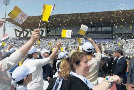  ?? Photograph­s by Jonathan Rashad For The Times ?? EGYPTIAN CHRISTIANS release balloons in the Vatican colors of yellow and white at the pope’s stadium Mass. “Even without entering, by the sound of the music you can feel the joy,” said a Nigerian priest. “Wherever he goes, he spreads the message of...