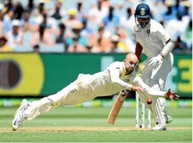  ?? GETTY IMAGES ?? Australian spinner Nathan Lyon dives to prevent a run off his bowling on the first day of the third test against India at the MCG yesterday.