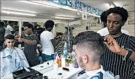  ?? CARON CREIGHTON/AP ?? Eritrean migrant Ghrmay Negassi works at a barbershop in Israel, where a new “deposit law” will cut migrant wages.