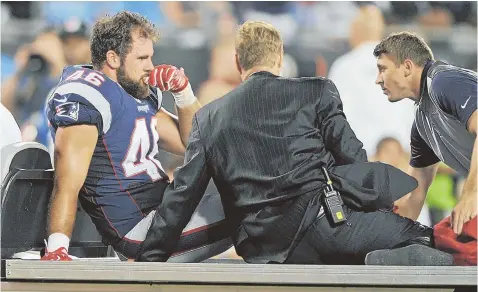  ?? AP PHOTO ?? PAINFUL MOMENT: The cold reality shows on the face of Patriots fullback James Develin as he is helped off the field on a cart after being injured during the second half of Friday night’s game against the Panthers in Charlotte, N.C. According to a team...