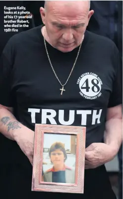  ??  ?? Eugene Kelly, looks at a photo of his 17-year-old brother Robert, who died in the 1981 fire