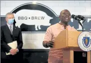  ?? CRAIG F. WALKER/GLOBE STAFF, POOL ?? Gov. Charlie Baker listens to African Community Center of Lowell Founder & Executive Director Gordon Halm speak about Commonweal­th Places Grants at Mill City BBQ and Brew in Lowell on Wednesday.