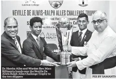  ??  ?? Dr. Harsha Alles and Warden Rev. Marc Billimoria hands over the Neville De Alwis Ralph Alles Challenge Trophy to the two skippers PIX BY SAMANTHA PERERA